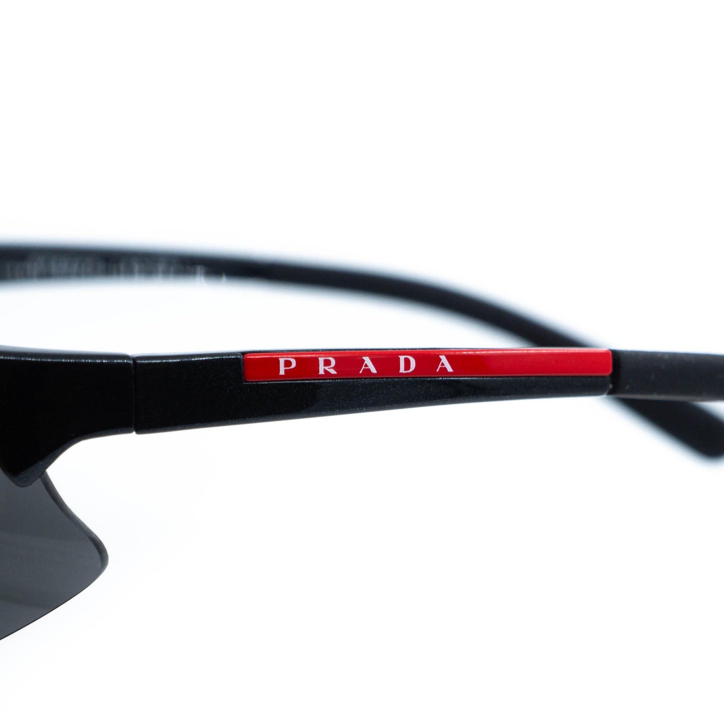 Close-up of Prada red Linea Rossa logo on temple