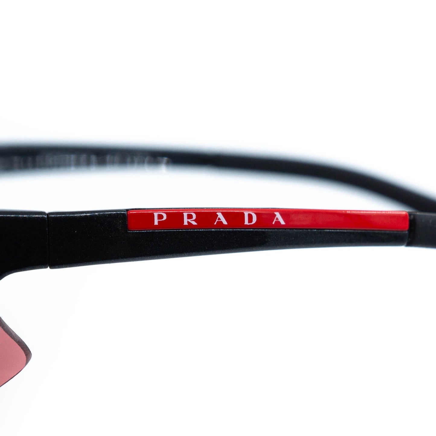 Close-up of red Prada logo on temple